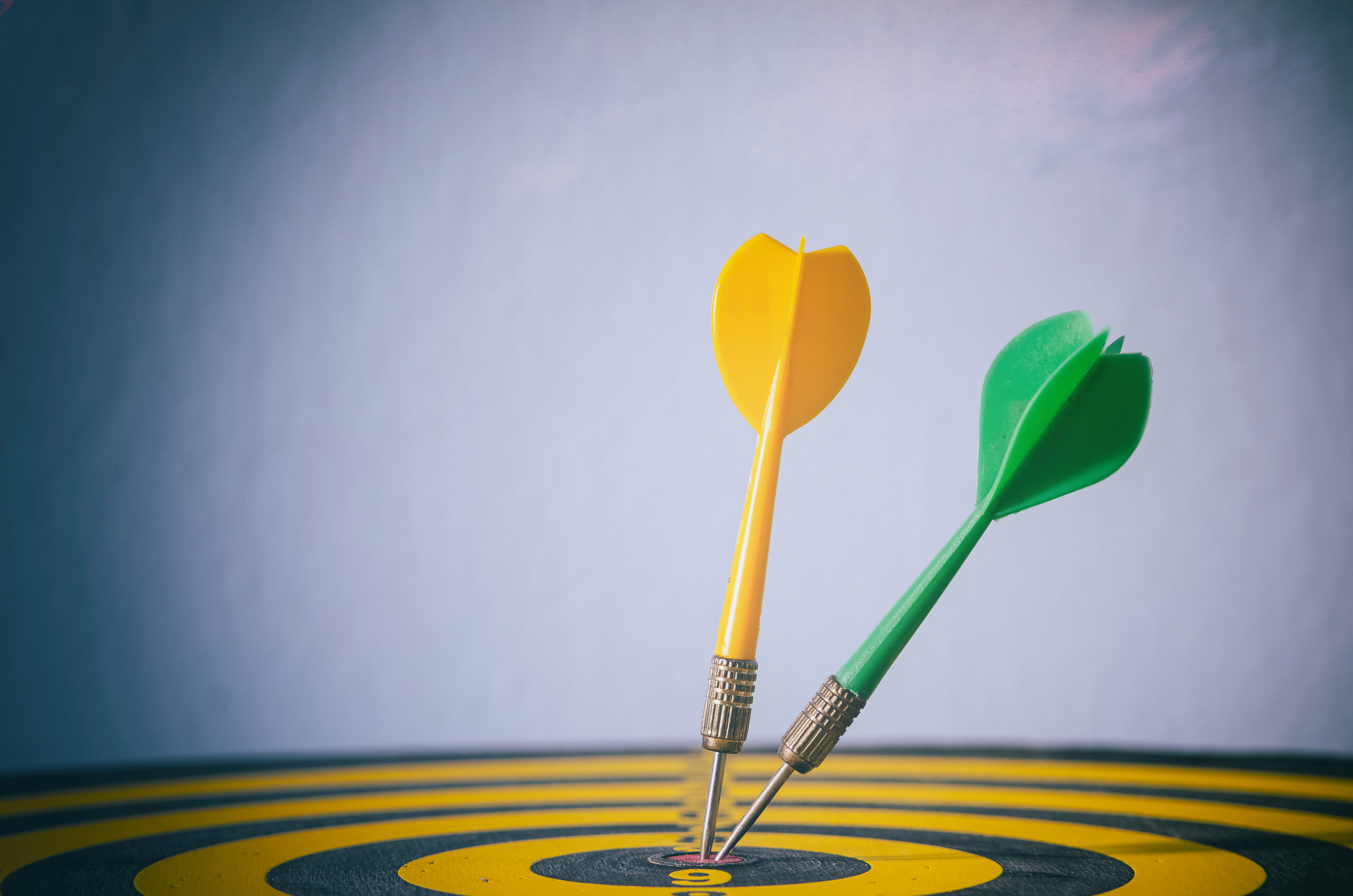 Yellow and green darts with target arrows