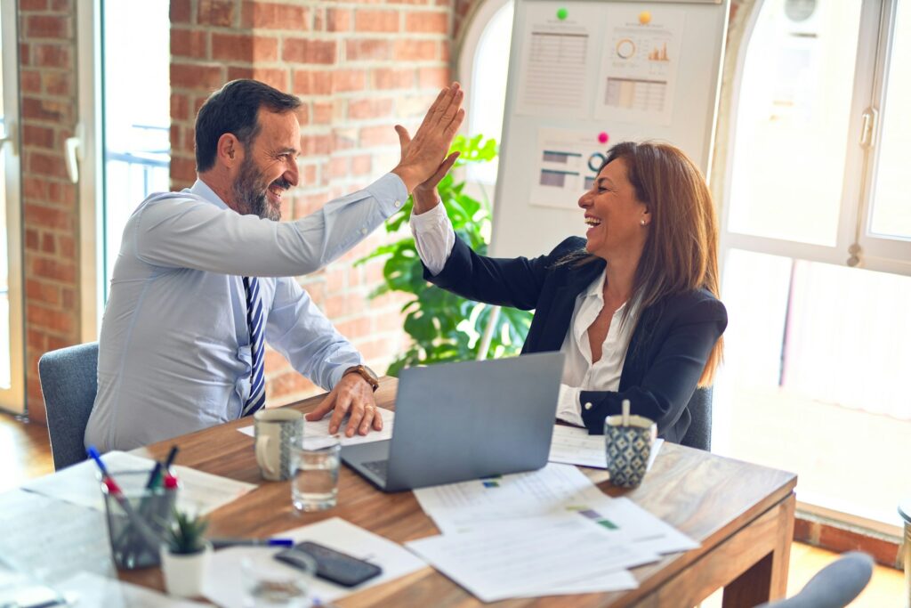 Two co-workers giving each other a high five