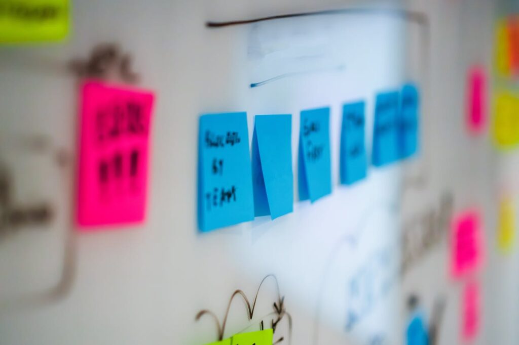 Blue, Pink and Yellow Sticky Notes on a white board